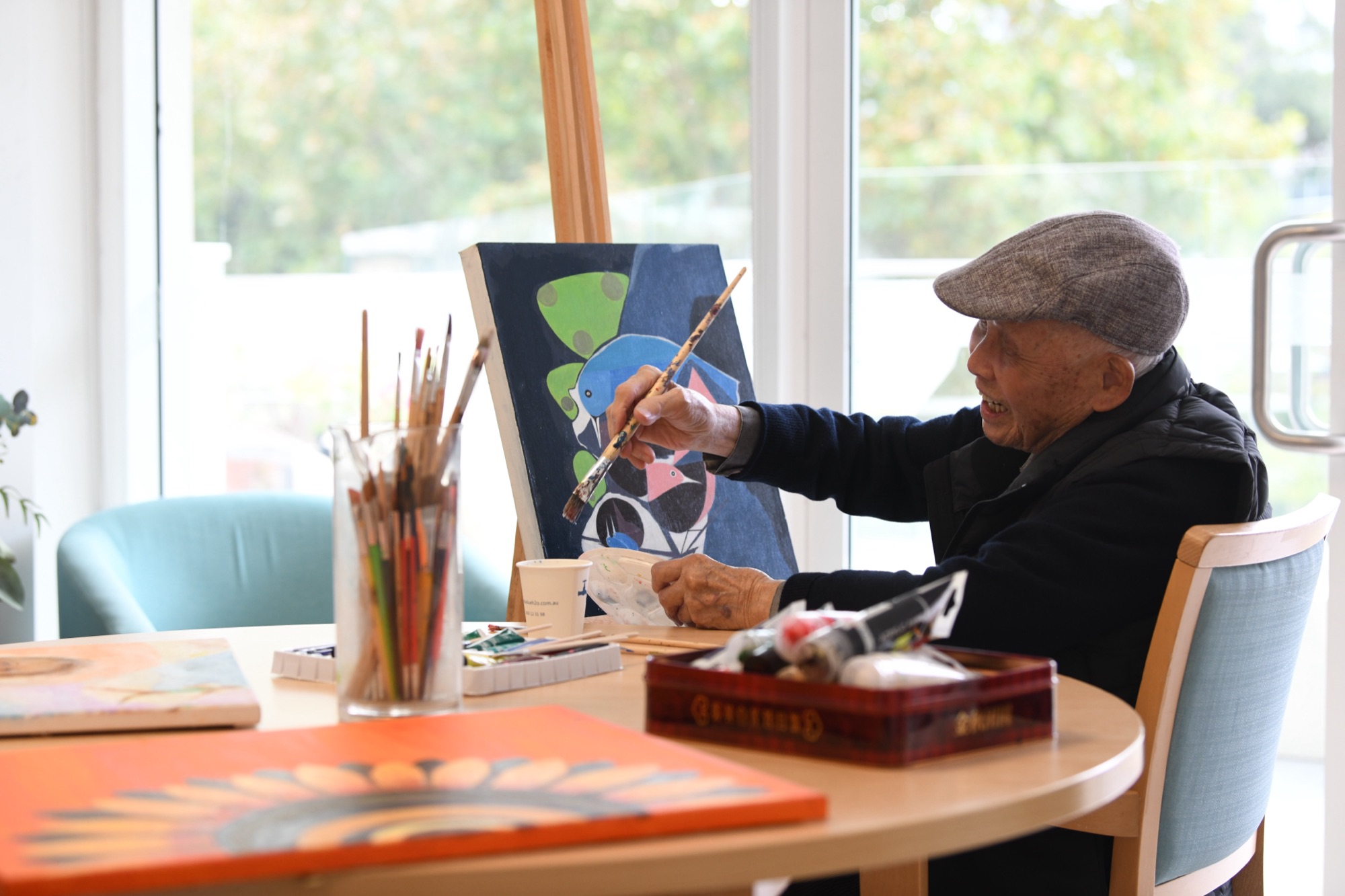 A resident painting at an easel