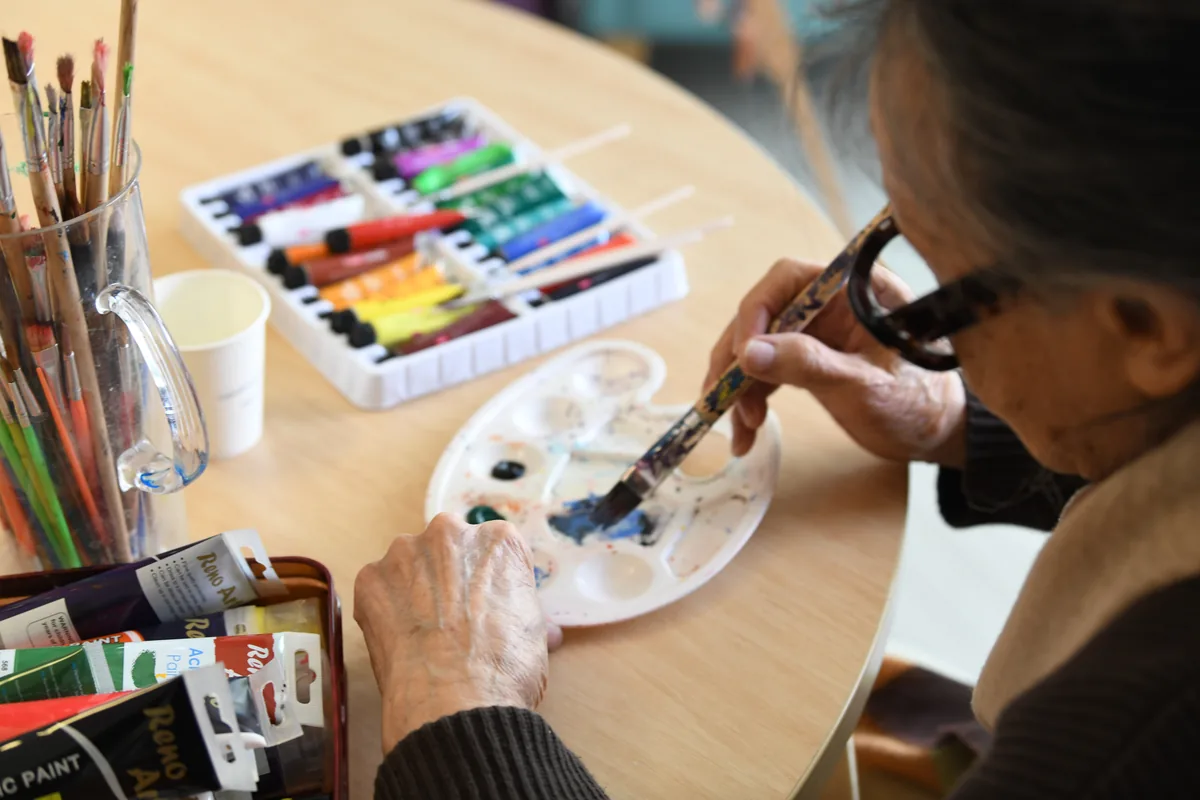A resident painting with brush and paint