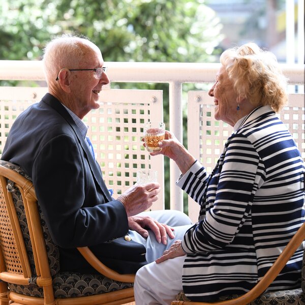 Couple enjoying the balcony at their Dougherty Apartments retirement living apartment.