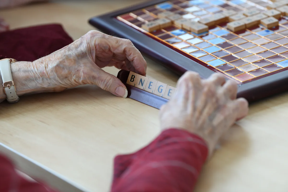 Hands playing Scrabble during a group activity
