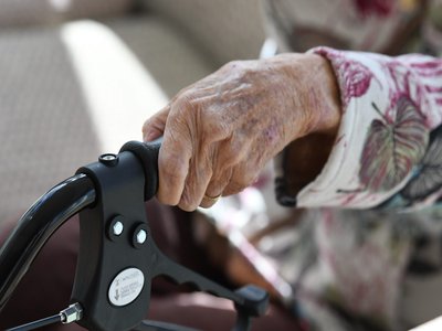 Resident using a wheel walker at Dougherty Apartments.